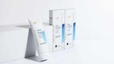 Dove Hyaluronic + Hydration Cream Serum, che contiene pro-ceramidi, niacinamide e peptidi di collagene. Confezione dal colore bianco, blu e oro.