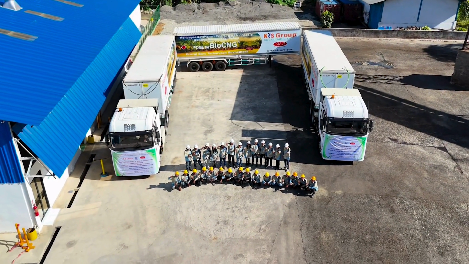 Veduta aerea di lavoratori e camion di biometano all’esterno di un impianto di olio di palma in Indonesia.