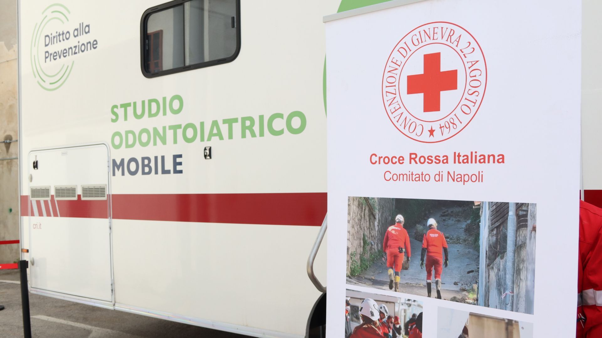 foto della clinica mobile e poster con scritto "Studio Odontoiatrico Mobile" e logo "Diritto alla Prevenzione"