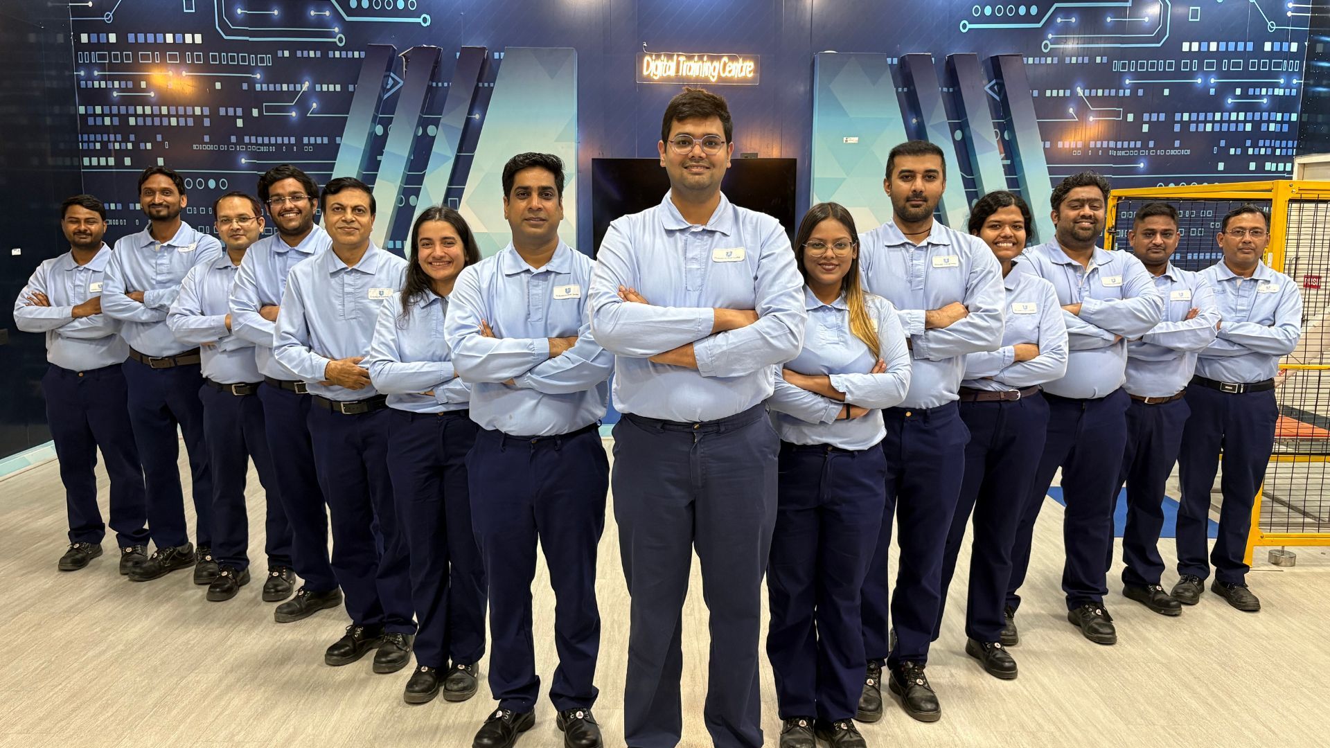 14 dipendenti della fabbrica di Bellezza e Benessere di Unilever a Tinsukia, in India, un sito della rete Lighthouse del WEF. Indossano camicie azzurre, stanno in piedi e sorridono alla fotocamera.