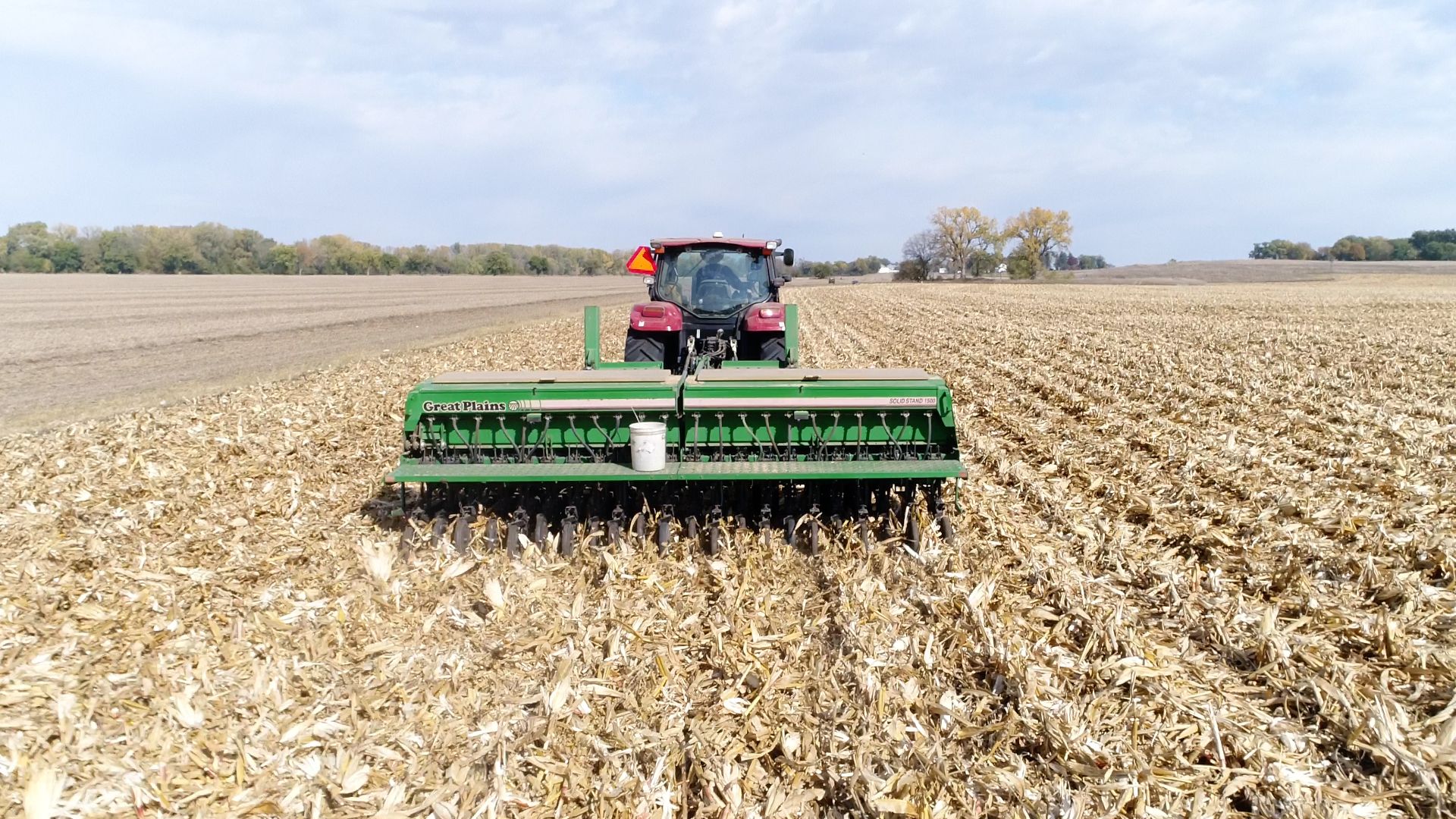 Un agricoltore su un trattore che lavora alle coltivazioni